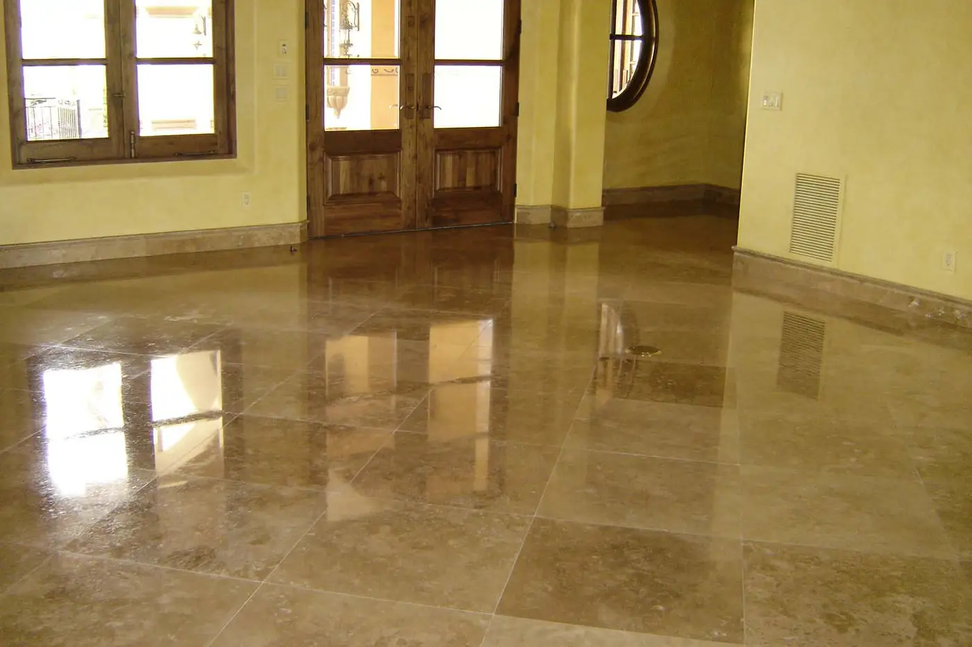 A travertine floor we cleaned, polished and sealed, reflecting the windows like glass